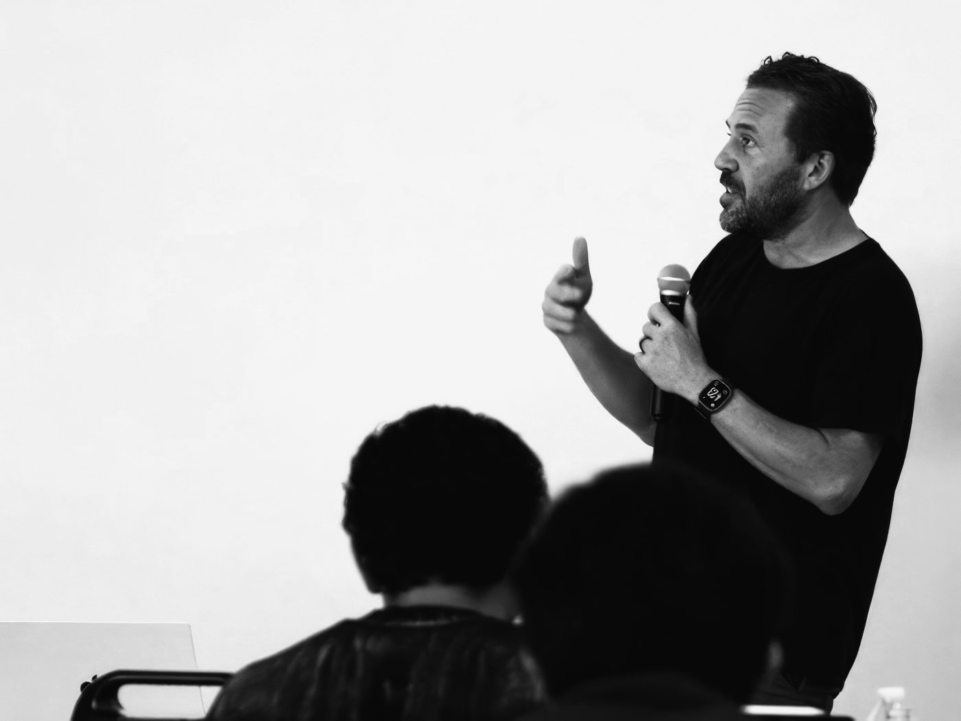 A speaker presenting to a seated room at a Claude community event.
