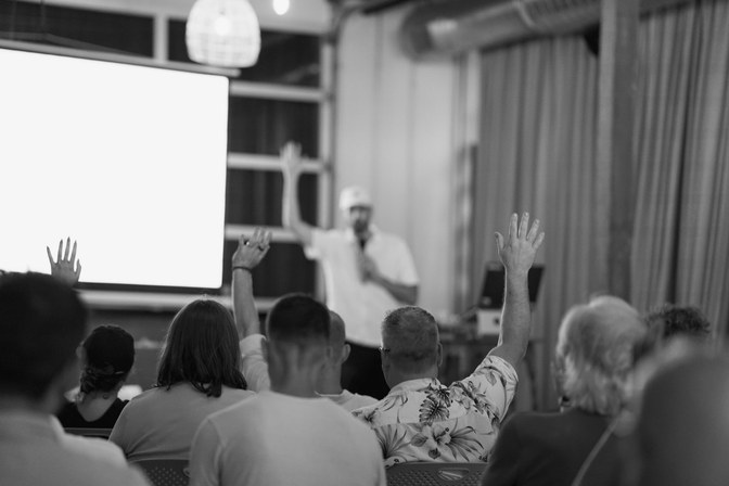 Hands raised in the audience at a Claude meetup