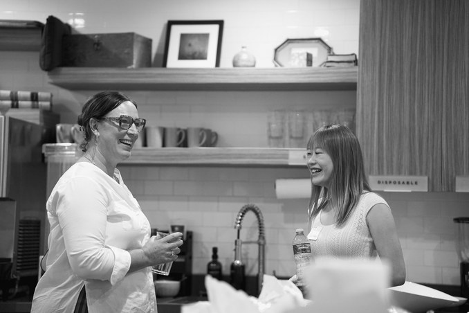Two attendees laughing in conversation at a Claude event.